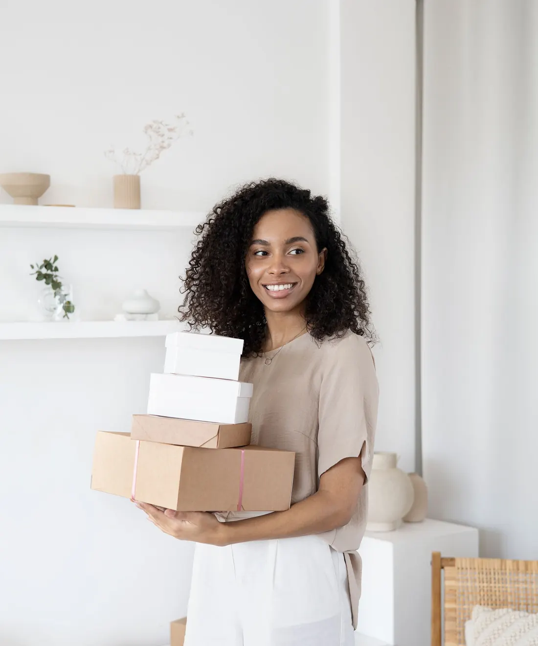 A smiling seller carrying a stack of parcels ready to send