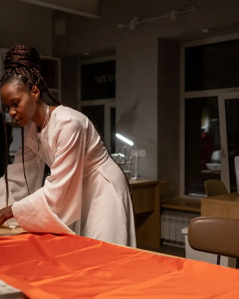 A fashion designer cutting fabric in her studio